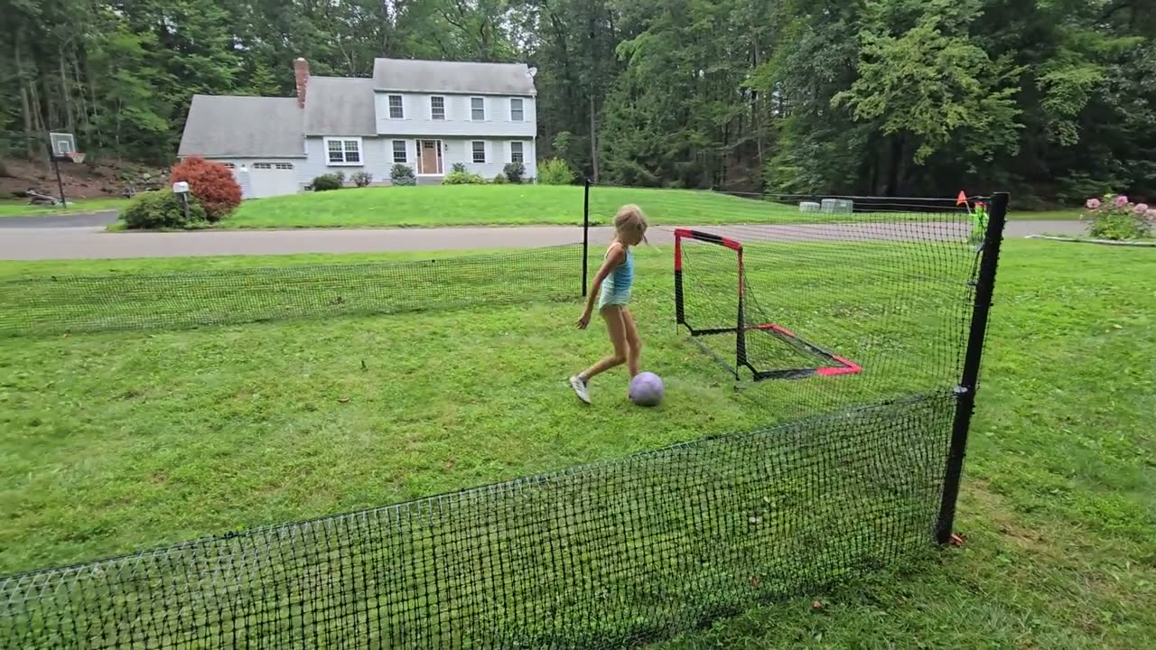 The field still in play: A sloped front lawn with goals at both ends — played on in daylight and under lights.