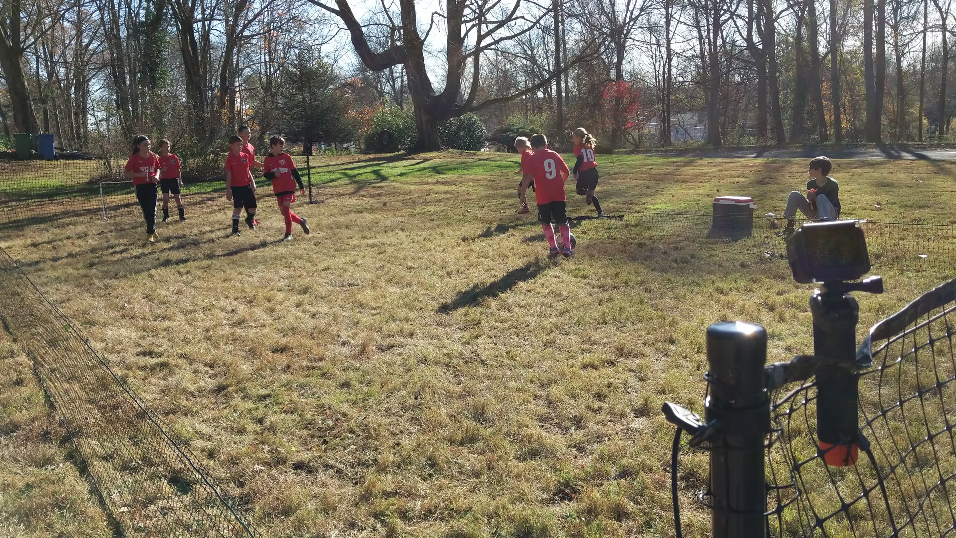 Children playing a backyard game inside a SoccerYards field with wall panels keeping the ball in play